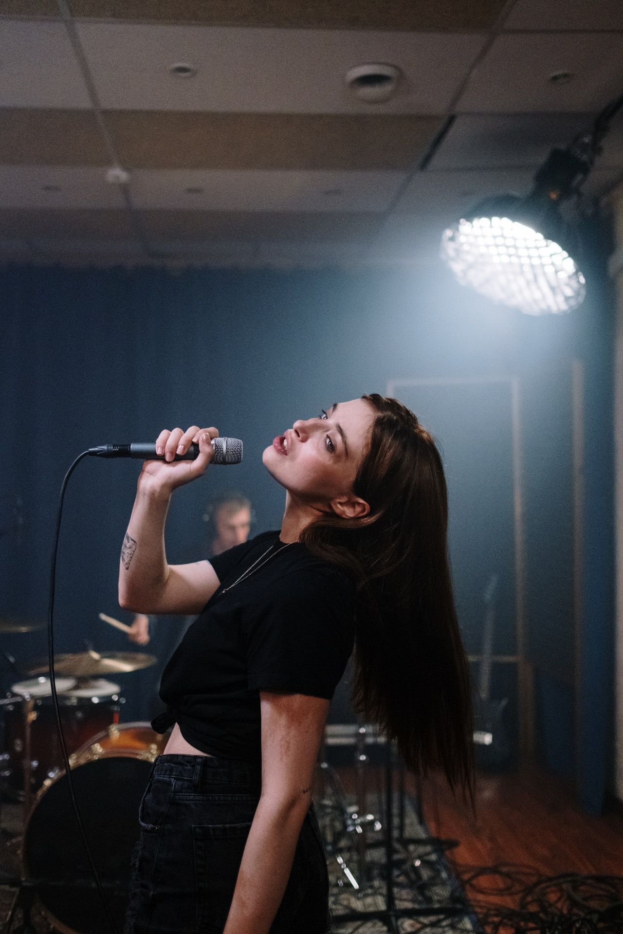 Singer performing with a microphone on a dark stage